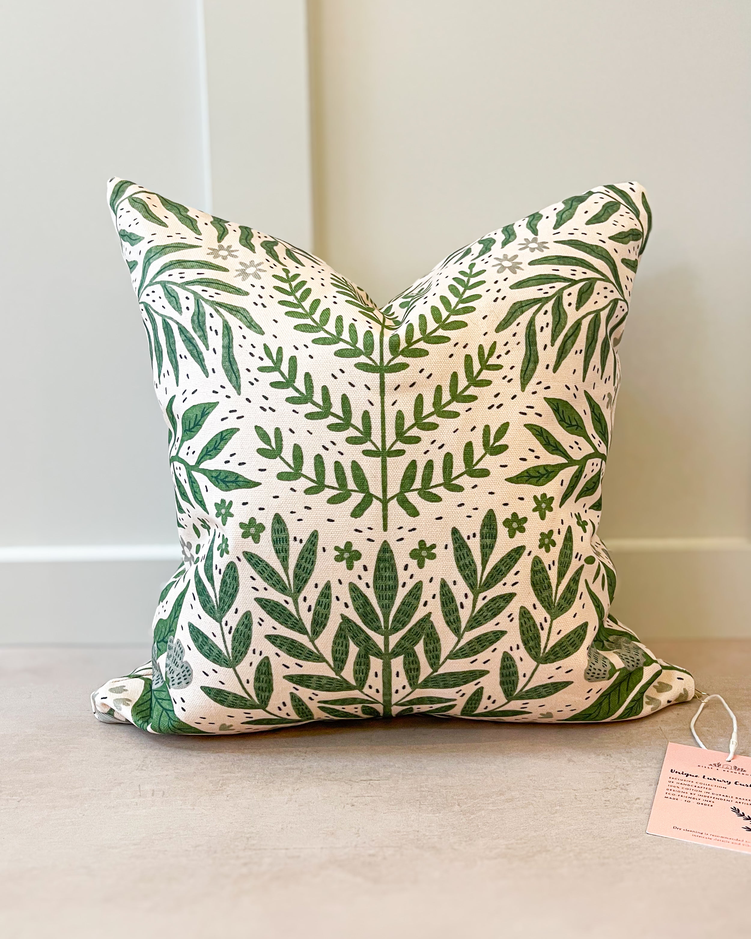 Botanical-inspired cushion with lush green and floral patterns, handmade in the UK from sustainable basketweave cotton.
