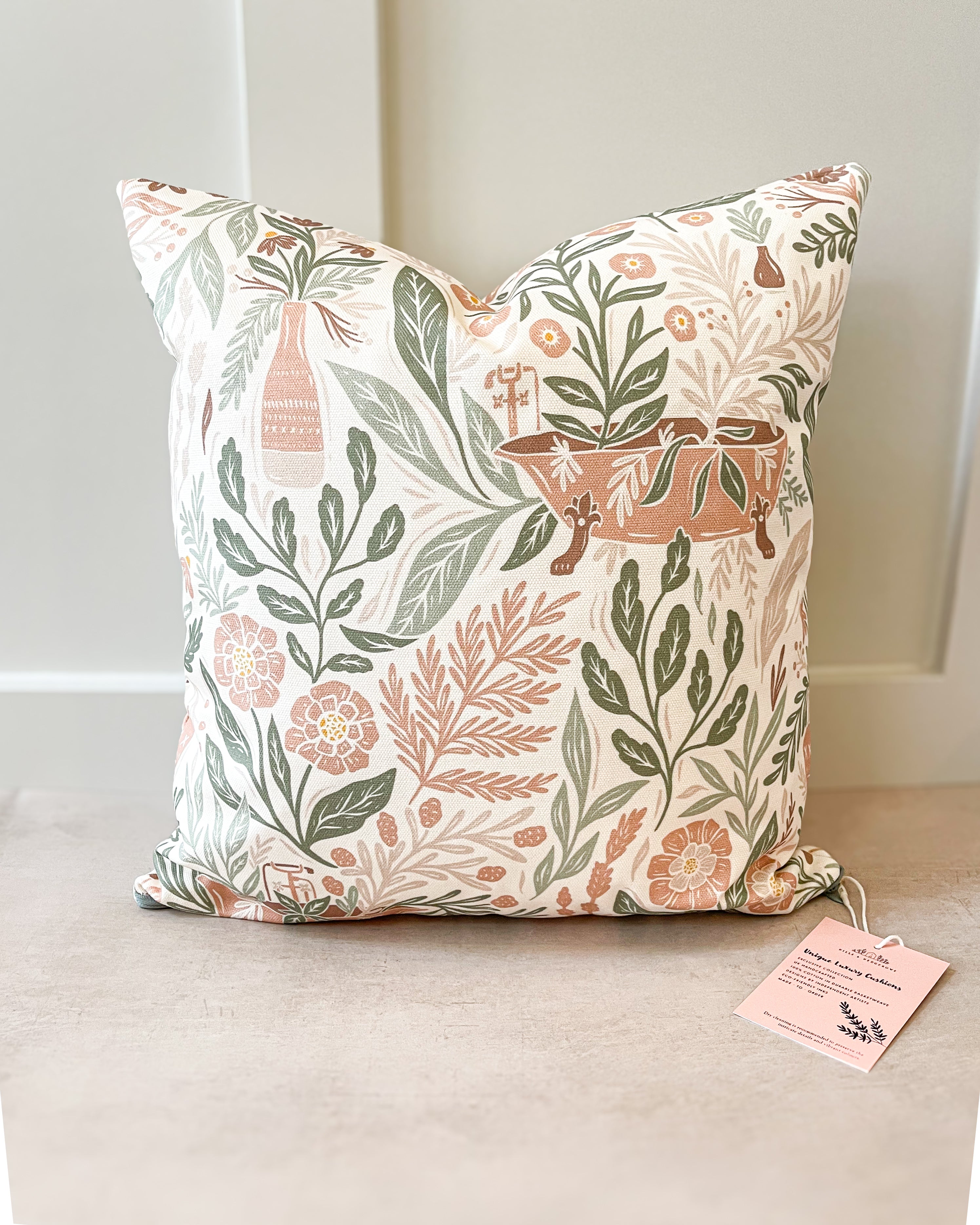 Botanical-inspired decorative cushion with lush green and floral patterns, handmade in the UK from sustainable basketweave cotton.