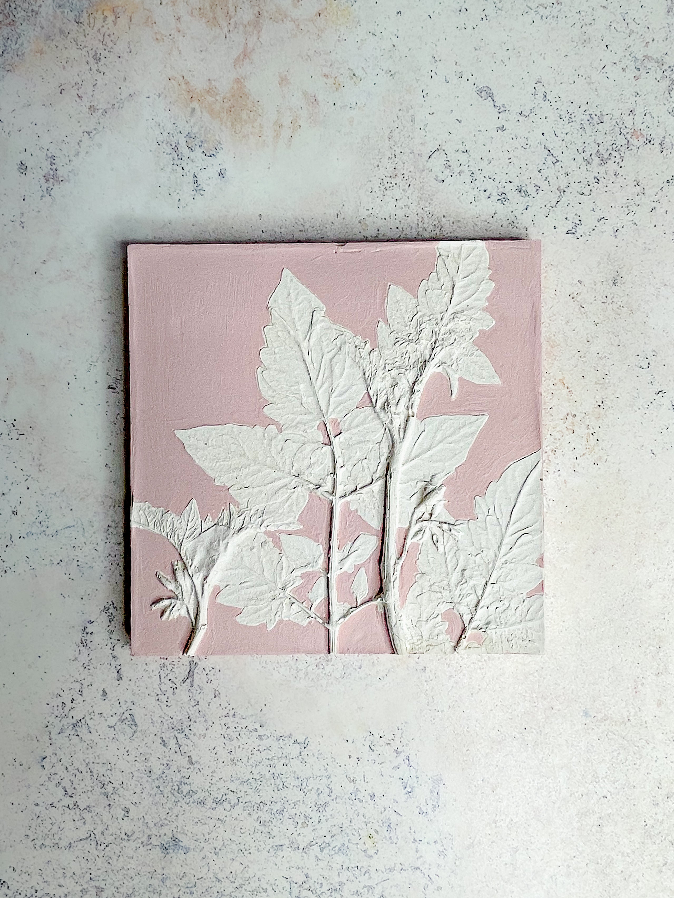 Handcrafted botanical relief tile with tomato vine imprint, hand-painted in dusky pink, symbolising growth and abundance