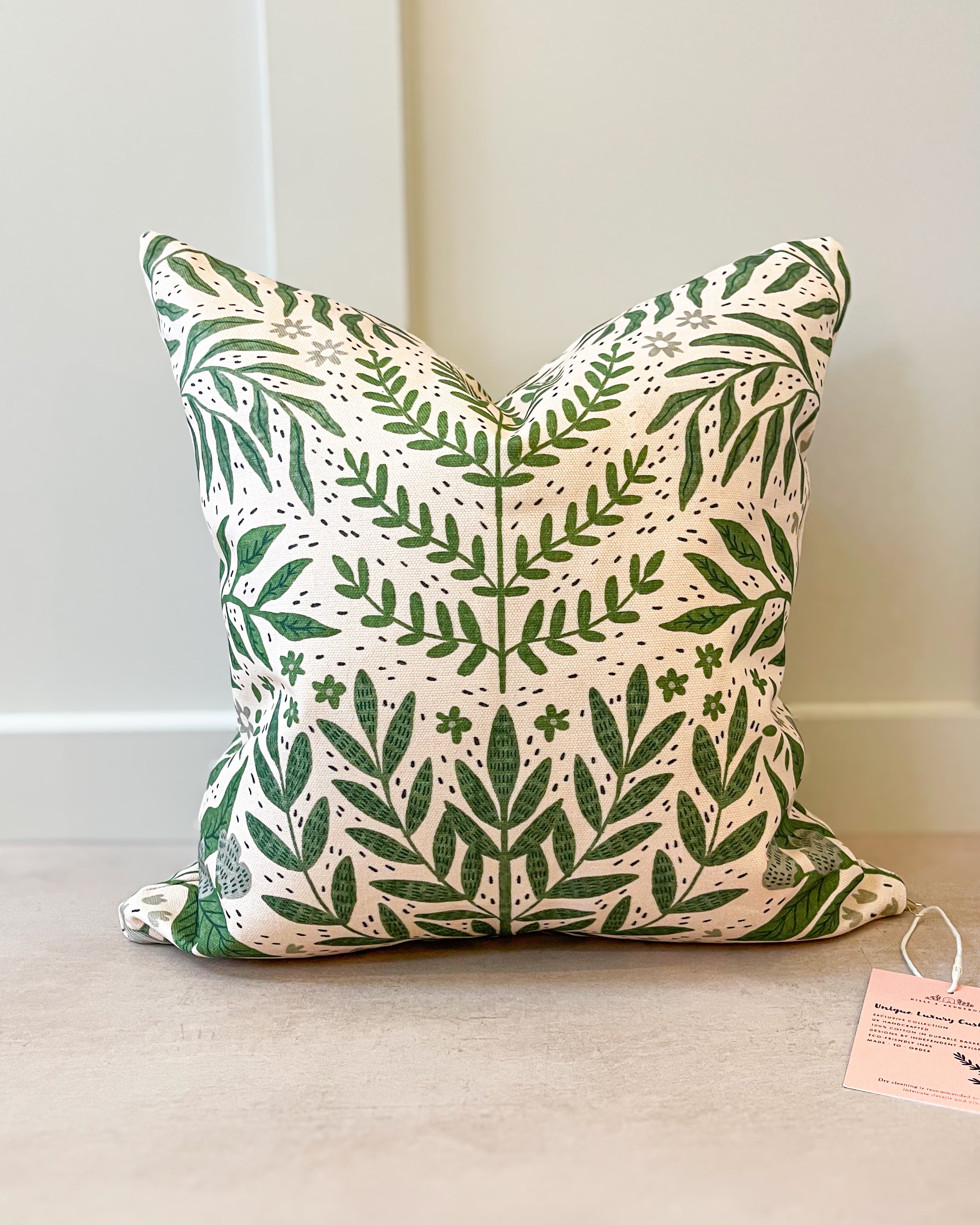 Tickling Greens Cushion featuring a green leafy pattern over a blush cream background, made of basketweave cotton with a duck feather insert, designed by independent artists.