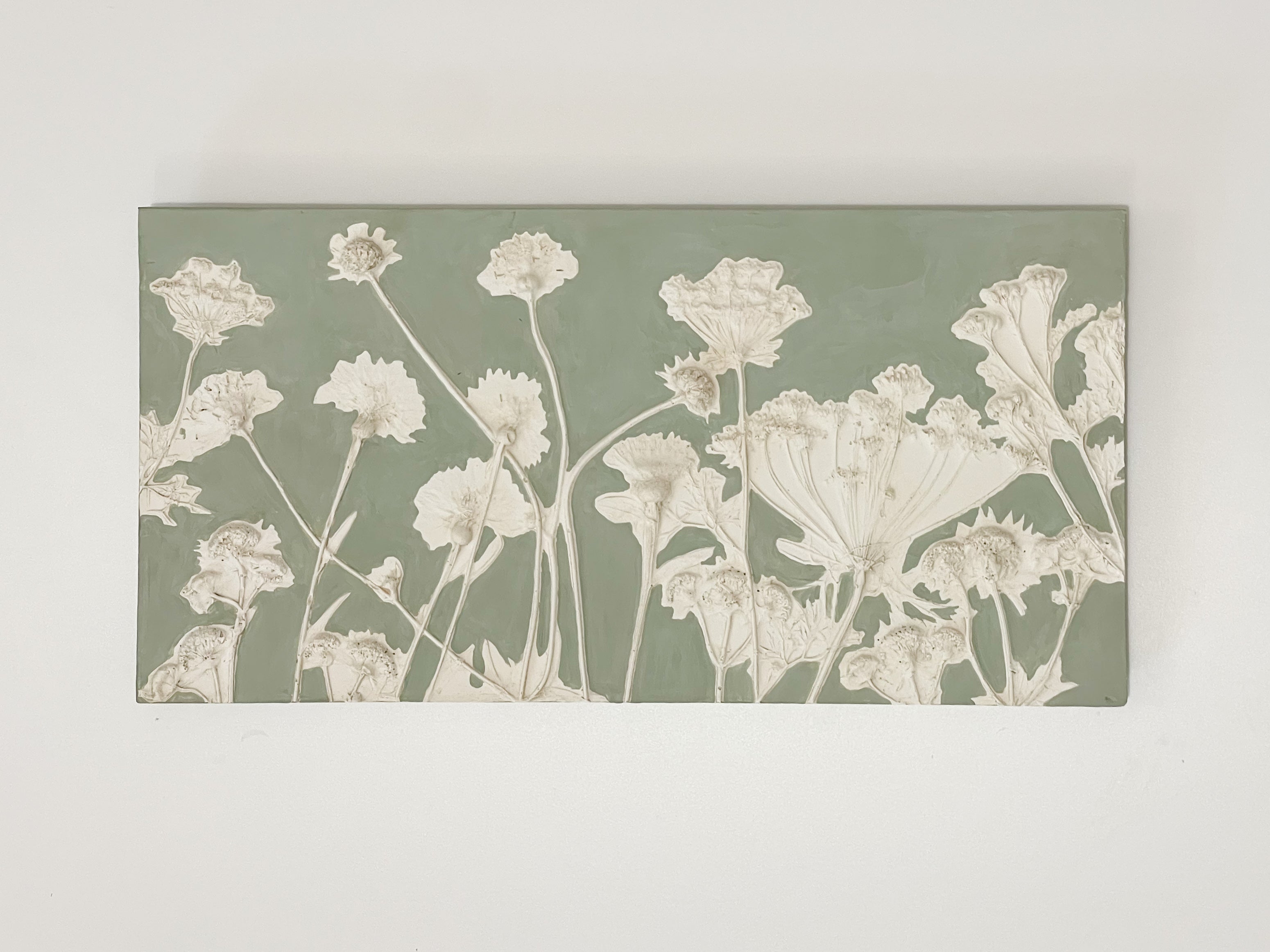 Handmade sage green plaster botanical relief plaque featuring Ammi and Cornflowers with rustic edges and metal D-ring hanger, crafted by Hills & Hedgerows.