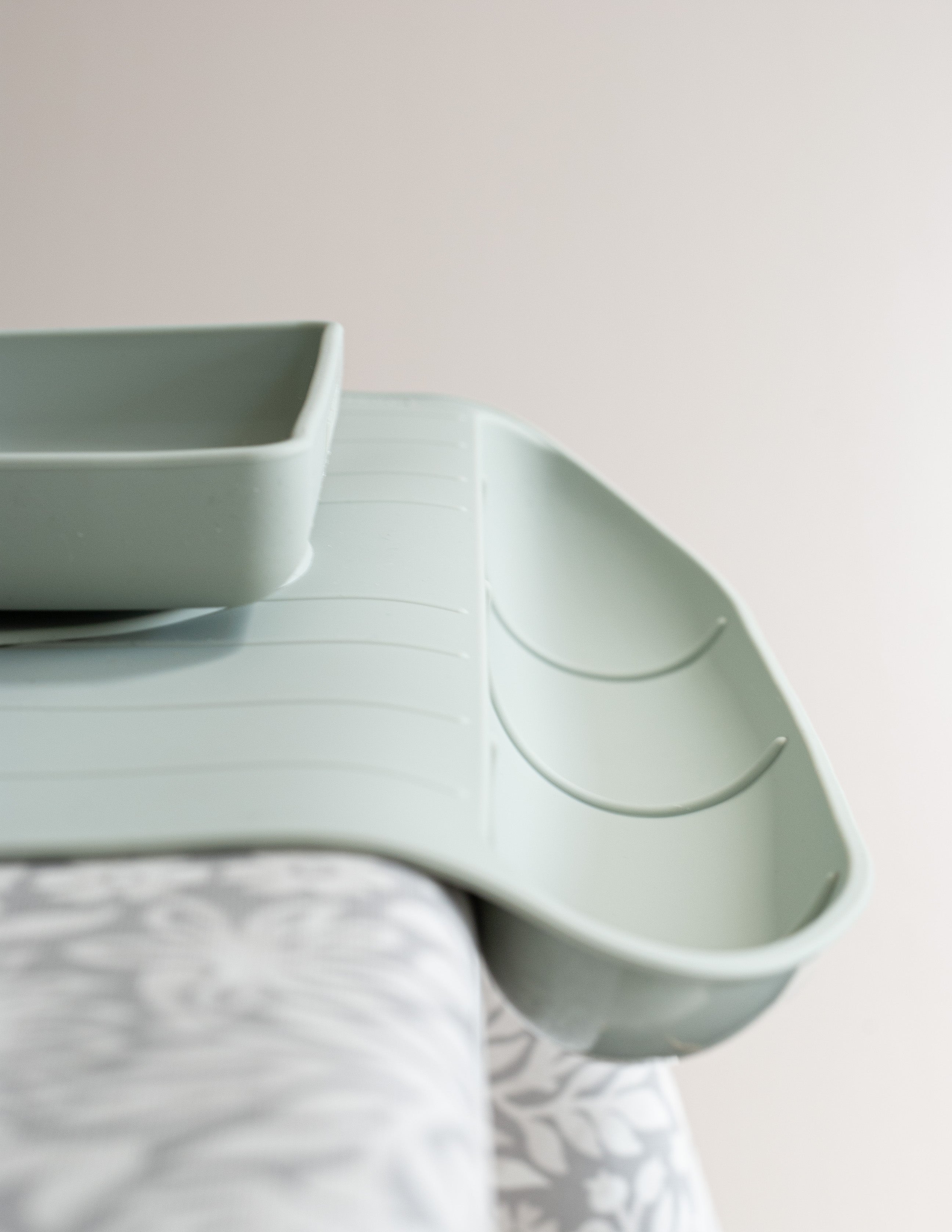A green silicone food catching table mat designed for babies and toddlers.