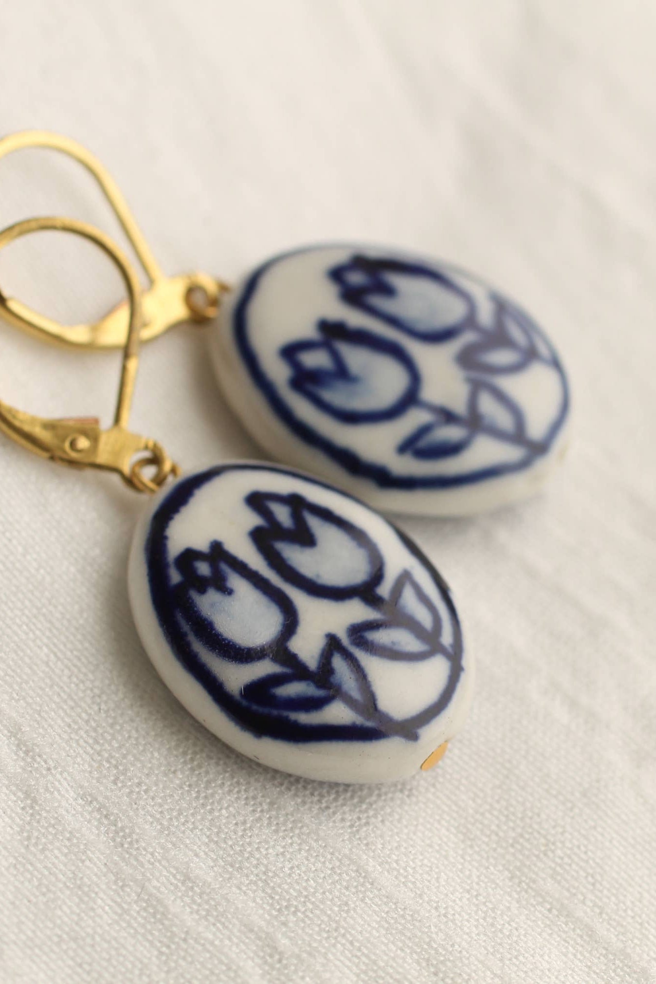 Handcrafted Oval Blue Tulip Earrings, porcelain with brass earwires. Nature-inspired design, perfect for autumn and winter, gift-ready in a cotton pouch.